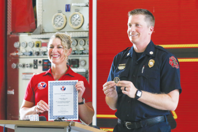  Angie Ott, a safety investigator with the U.S. Consumer Product Safety Commission, presents Farmington Hills Fire Department Fire Marshal Jason Baloga with a certificate for the role he played in helping to launch an investigation into a potentially unsafe product. 