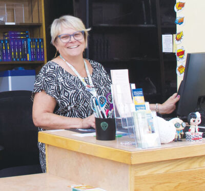  Linda Downey, circulation clerk at the Fraser Public Library, works the checkout desk on Aug. 1. 