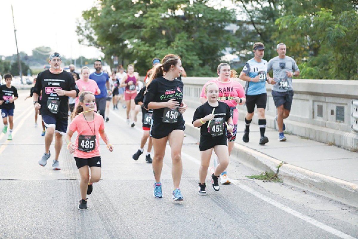  Runners take part in the annual Cassie Hines Shoes Cancer Foundation Glow Run 5K and walk, which begins and ends at Jimmy John’s Field in Utica. This year’s Glow Run will take place Sept. 14. 