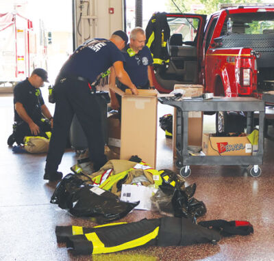  Macomb Township firefighters unload new turnout gear, partially paid for by a state grant, at the township’s Station 1. 