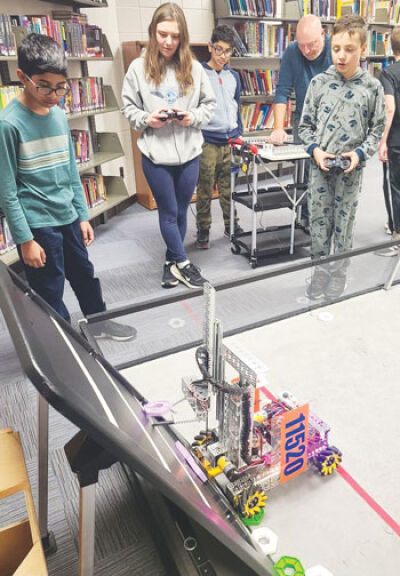  Members of the Omegabots robotics team at Larson Middle School work together on various tasks to prepare for robotics competitions. 