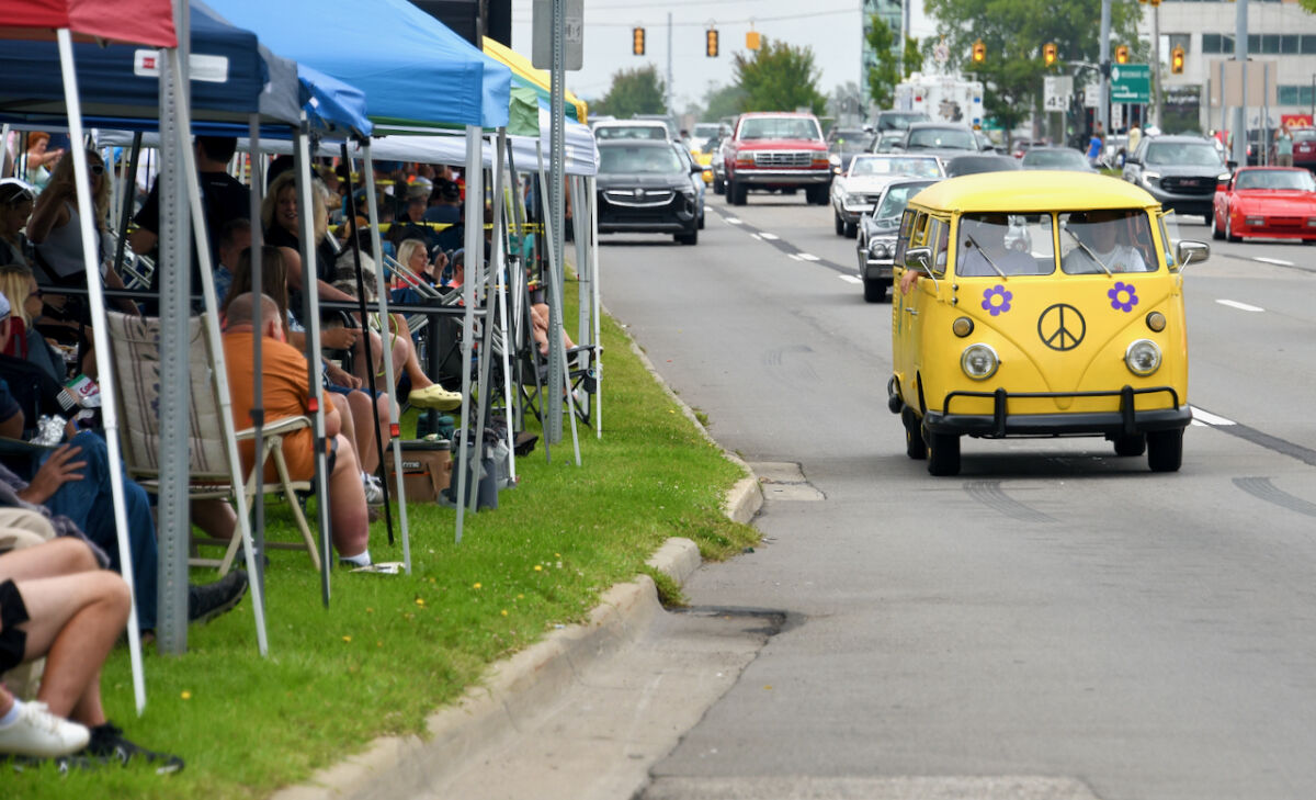  On Woodward Avenue, attendees view a hippie-style bright yellow Volkswagen van passing by Aug. 17.  