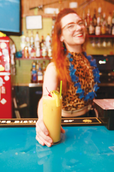  Molly Mackler, bartender at Eastern Palace Club in Hazel Park, prepares a “painkiller” cocktail. Legislation that will go into effect  next year will change how workers are compensated in Michigan, including tipped workers in the service industry. 