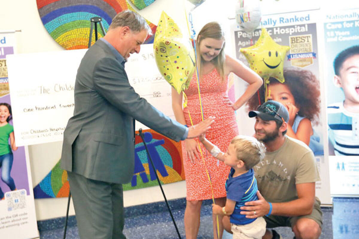  “Full House” actor Dave Coulier high-fives a child at the Children’s Hospital of Michigan in Detroit. 