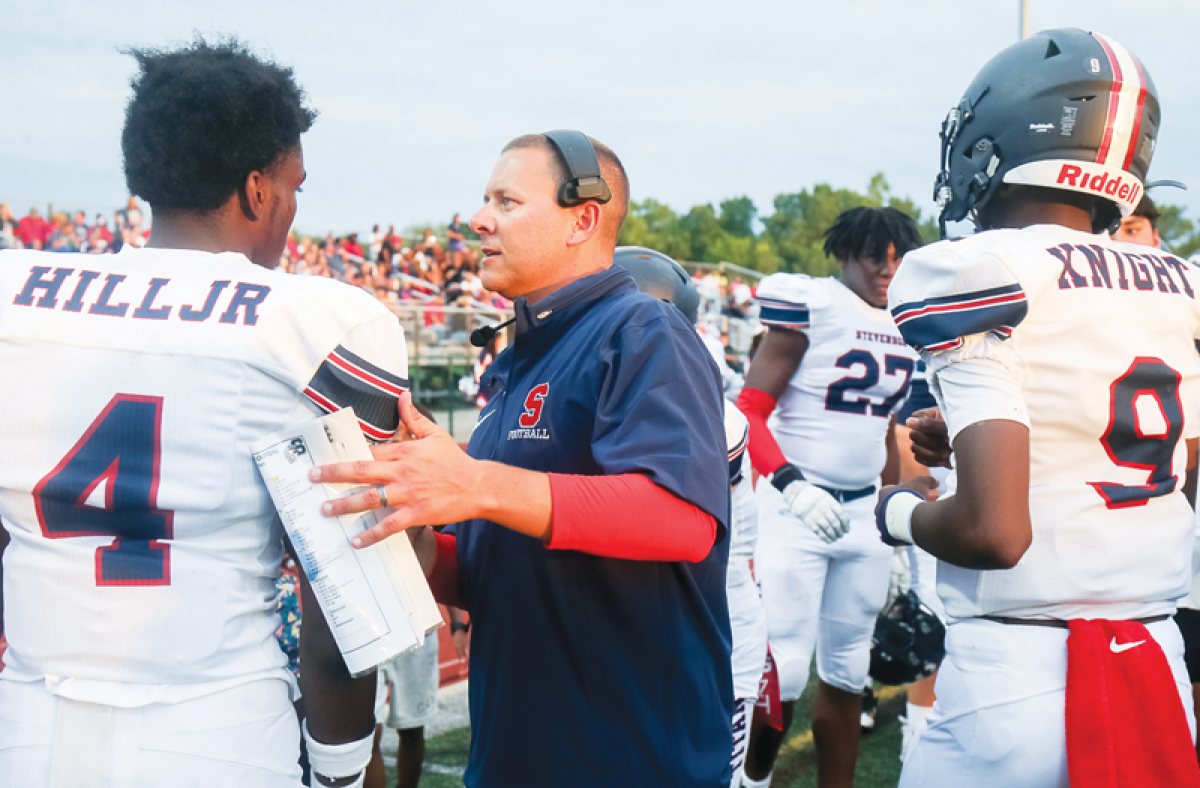  Sterling Heights Stevenson head coach Justin Newcomb talks with junior wideout Ronnie Hill.  