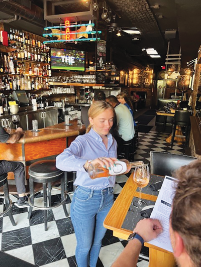  A member of the waitstaff at Streetside Seafood in Birmingham serves a guest. 