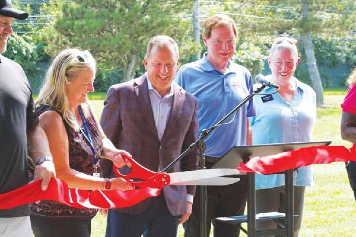  Clinton Township Department of Public Services Director Mary Bednar cuts the ribbon for a new paved path in Prince Drewry Park on Aug. 14. Bednar is pictured with Trustee Dan Kress, far left, Treasurer Paul Gieleghem, center, Supervisor Bob Cannon, second from right, and Trustee Julie Matuzak, far right. 