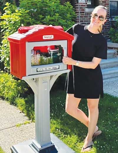  Katie Mezwa, pictured, said she wanted to give back to the community by providing this “free dog library.” She encourages neighbors to take any and all supplies they need. 