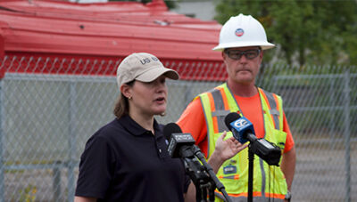  Environmental Protection Agency Communications Specialist Allison Lippert, left, introduces the EPA’s on-scene coordinator for Region 5, Sean Kane. Kane provided an update about the agency’s cleanup following the March 4 Goo Smoke Shop explosion. 