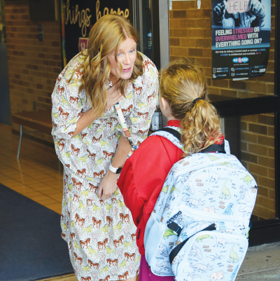   On the first day of school Sept. 3 in Warren Woods Public Schools, new Briarwood Elementary Principal Beth Mager greets students, including first grader Isabel Brewer, age 6.  