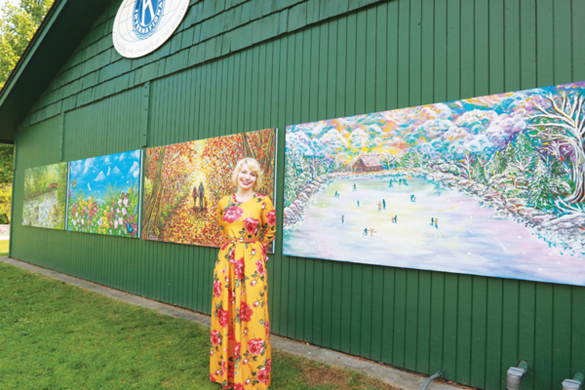  Artist Chelsea Hensbergen shows off the four season mural she painted for the Kiwanis Shelter at Rochester Municipal Park.  