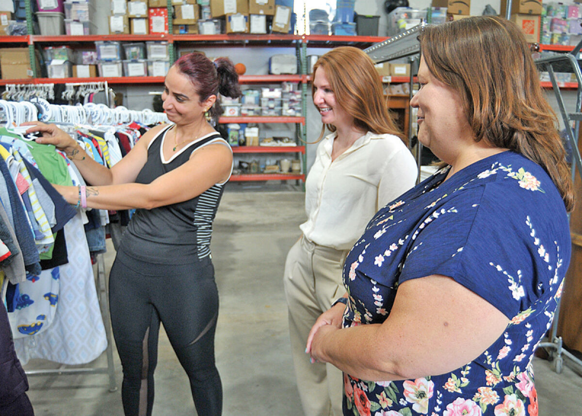  From the left, Diana Al Akona, Courtney Morrow and Kristin Olmedo look through some of the children’s clothing items offered to clients through the United Community Family Services/Chaldean American Ladies of Charity. 