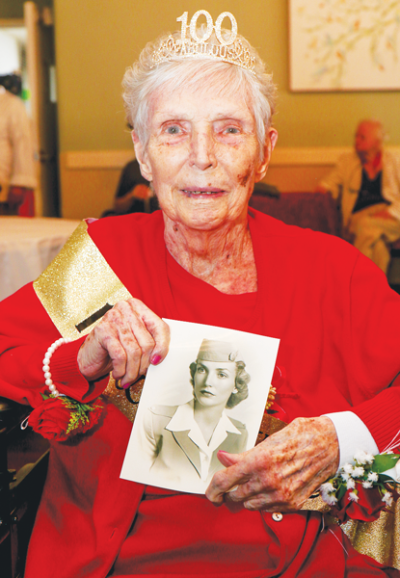  Anita Cozzens, who celebrated her 100th birthday Sept. 16, holds up a photo taken during World War II when she was a flight attendant and served many service members en route.  