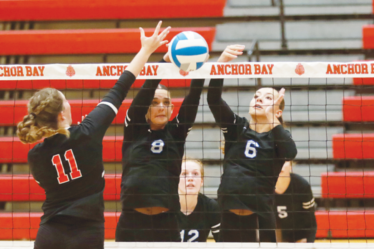  Utica Eisenhower junior Gina Fedrigo, left, and senior Nicole Rek, right, go up against a New Baltimore Anchor Bay player. 