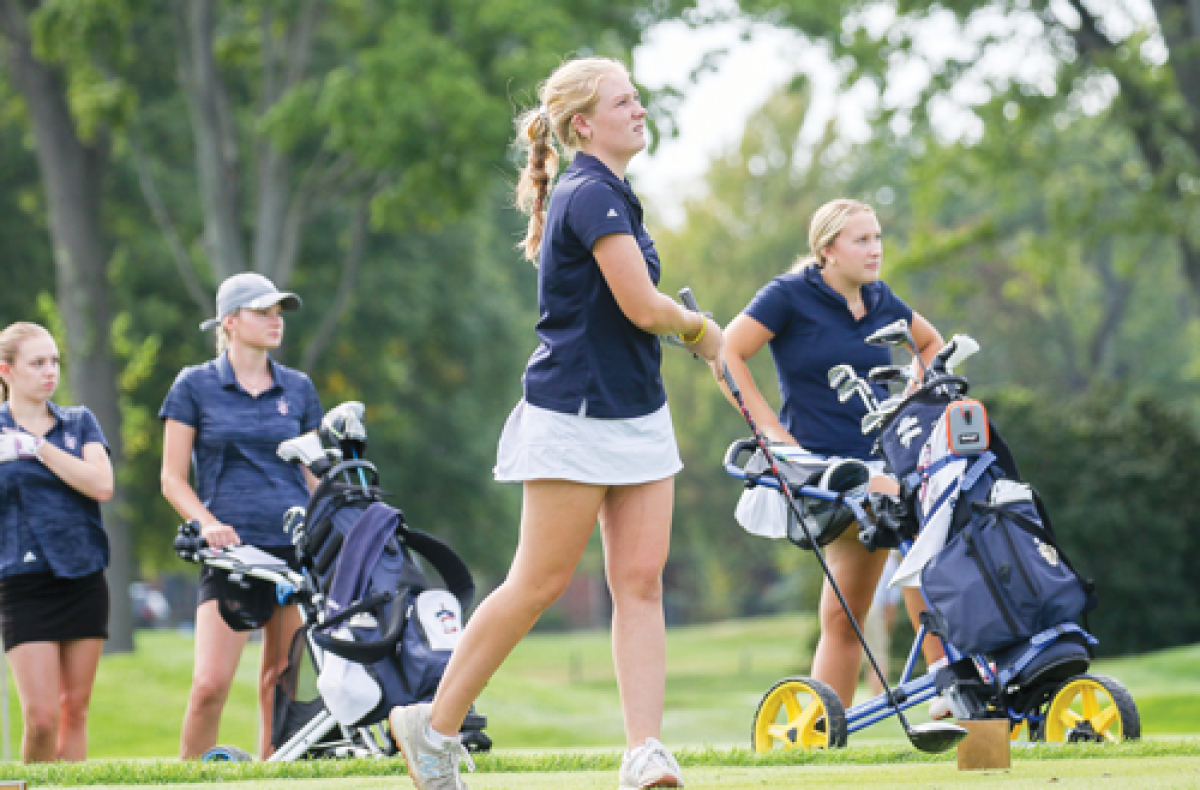  Grosse Pointe South junior Lyla Hampton tees off while senior teammate Murphy Russell, right, looks on. 