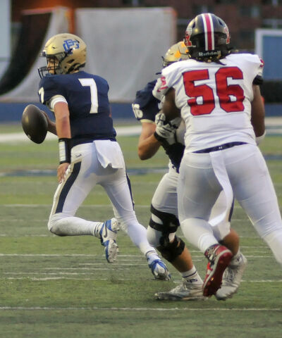  Grosse Pointe South senior quarterback Jack Lupo scrambles outside the pocket with Roseville senior Michael Chude providing the rush. 