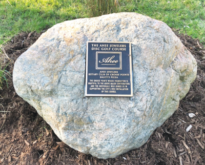  A rock and commemorative plaque near the first hole of the Ahee Jewelers Disc Golf Course in Grosse Pointe Woods acknowledges the donors who made the course possible. 