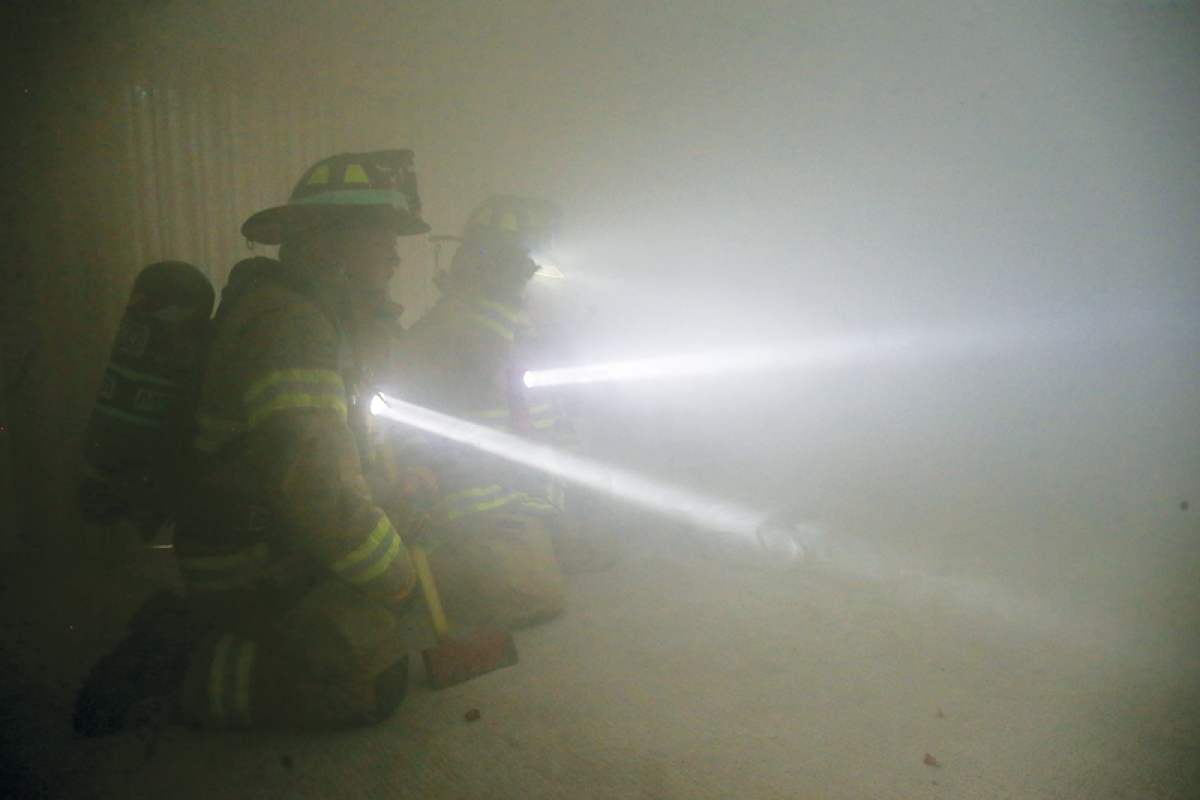  Visibility is extremely limited for first responders at fire scenes, so they have to rely on their training and each other, as this exercise at a home on Lake Shore Road demonstrates. 