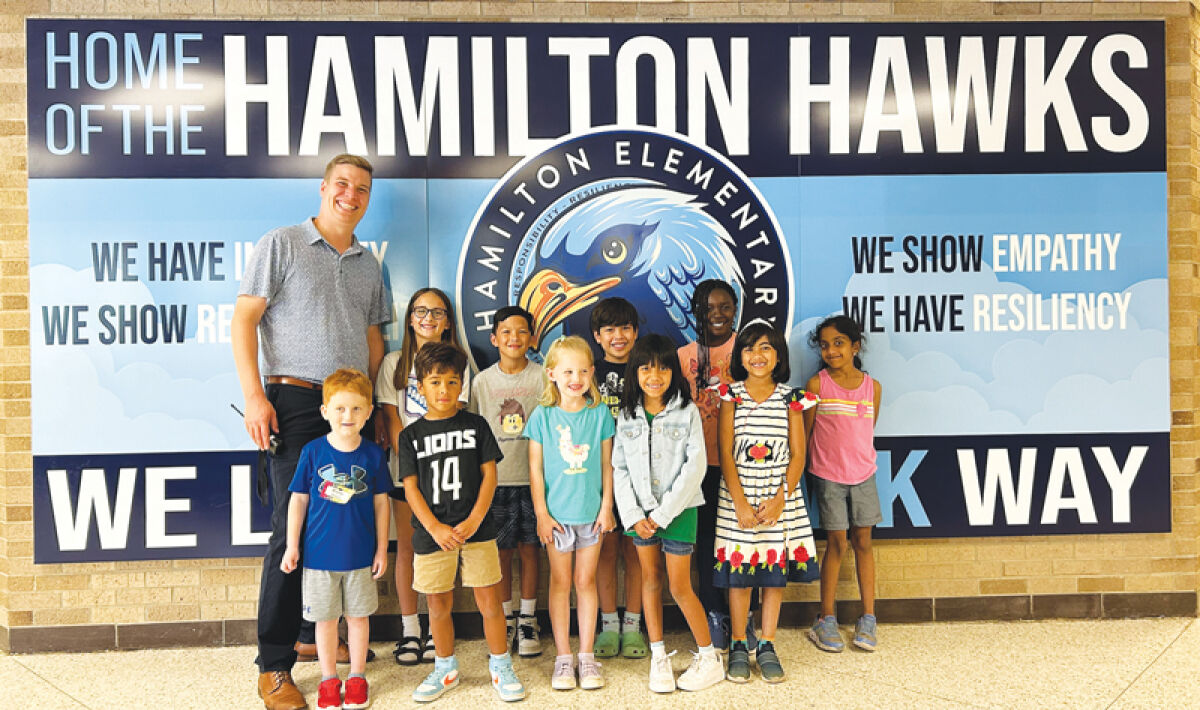  Hamilton Elementary School principal David Recker stands with some of the school’s students. 