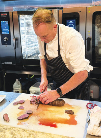  Paul Grosz, the owner and executive chef of Cuisine Restaurant and a Schoolcraft College Culinary Arts instructor, prepares a roasted venison loin for the third course of the Harvest to Table Gala Oct. 1 at the Great Lakes Culinary Center. 