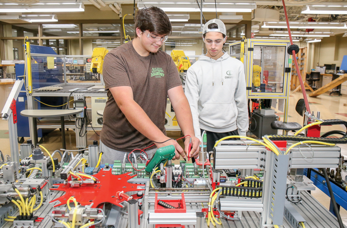  Lake Orion High School seniors Logan Silaghi, left, and Brodey Selent, right, work on an assembly system. The workstation lets students experience an integrated work system and utilize electrical and mechanical systems at Oakland Schools Technical Campuses- Northeast. 