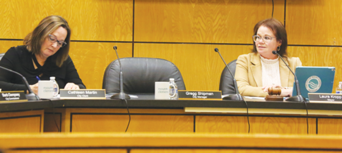  Mount Clemens City Clerk Cathleen Martin, left, and Mayor Laura Kropp, right, flank the empty chair of City Manager Gregg Shipman. The city manager sustained injuries in an accident and is working remotely as he recovers.  