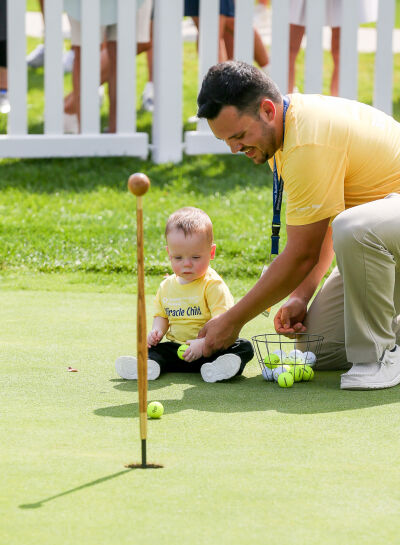  Miracle Kid Everett LaBrash, 1, gets help from Dad Alex LaBrash during the putting challenge. 