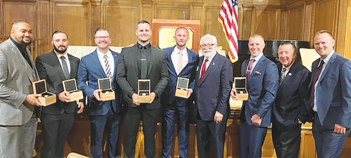  The six Valor Award winners display their engraved Shinola watches. The officers are joined by emcee Paul W. Smith, Hundred Club President William Packer and Lt. Brent Chisolm.  