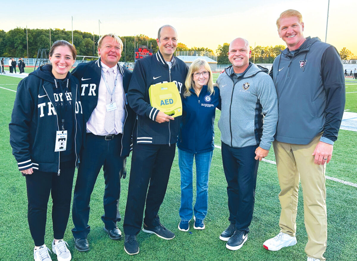  State Rep. Sharon MacDonell presents an AED to Troy School District faculty members Oct. 10. The presentation occurred before a football game between the Colts and the Farmington High School Falcons. 