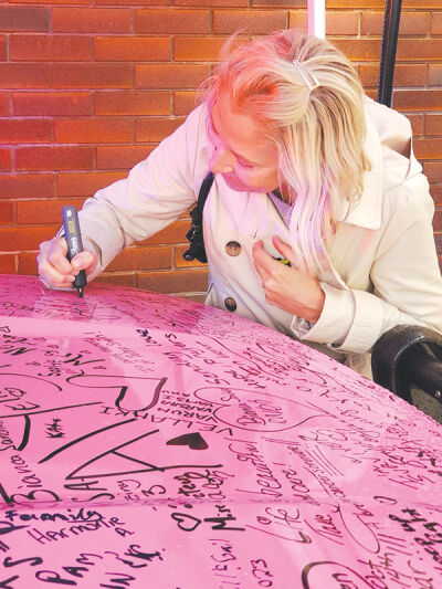  Community member participates in signing the vehicle.  