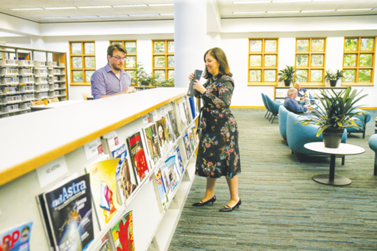  Teen librarian Matt Kessler and Library Director Juliane Morian tidy up the magazine section. 