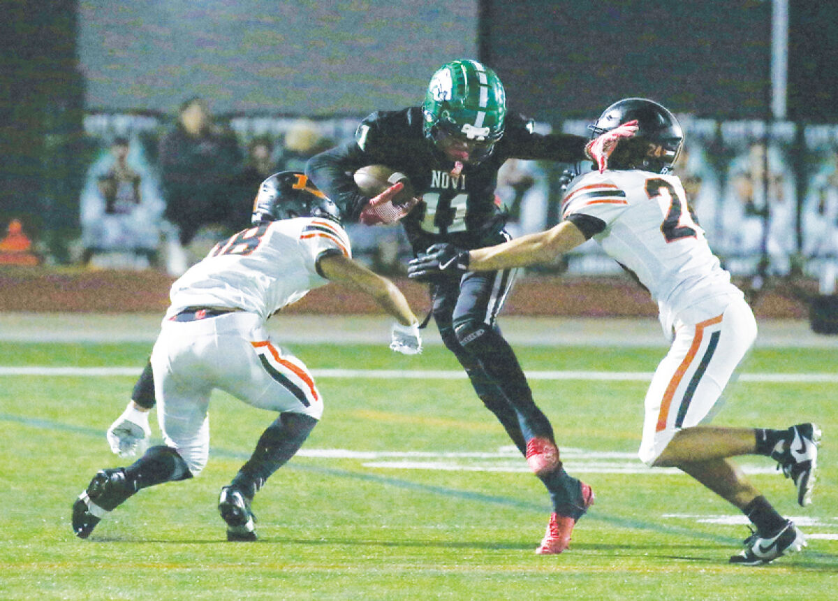  Novi sophomore wide receiver Christian Gillings fights off defenders. 