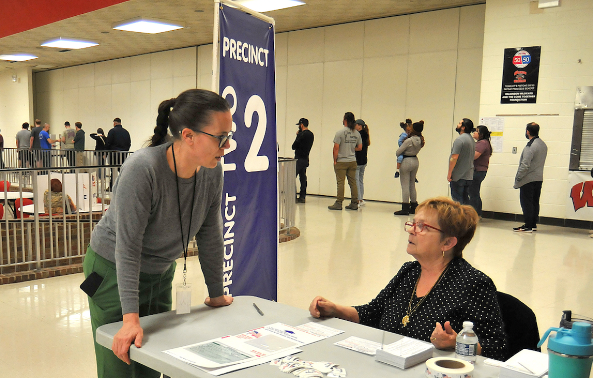  Sonja Baldwin-Siegmann, chair of Precinct 2 in Madison Heights, consults with poll worker Linda Corbett, seated, as voters line up inside Wilkinson Middle School during the election Nov. 5. 