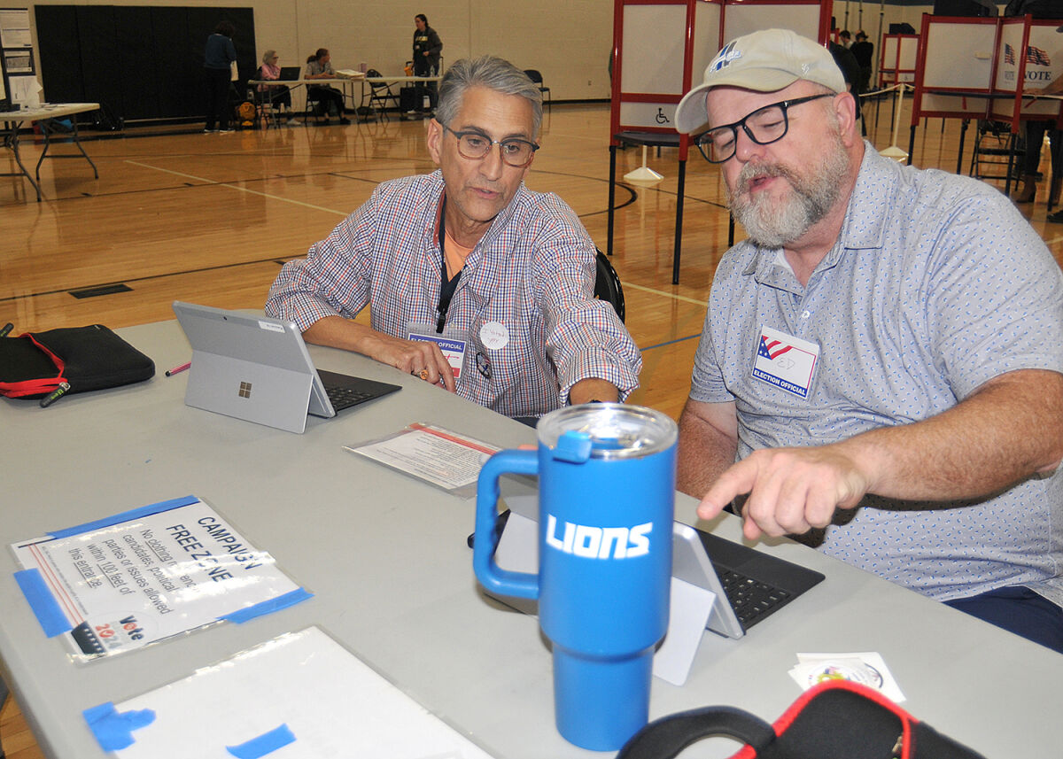  Royal Oak poll workers Kurt Von Eberstein, left, and Ed O'Sullivan wait for voters to arrive at Royal Oak High School Nov. 5. 