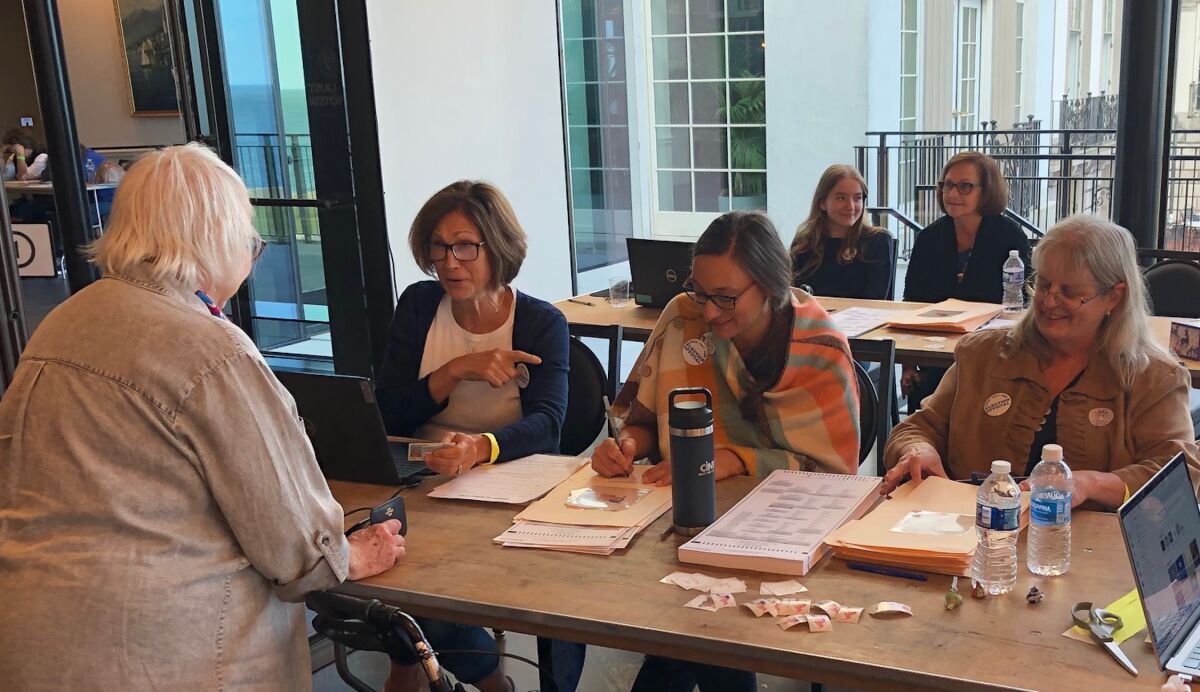  From left, Grosse Pointe Farms Precinct 2 election inspectors Patricia Cardoze, Julie VanMarcke and Michelle Steele assist a voter on Election Day Nov. 5 at The War Memorial. 