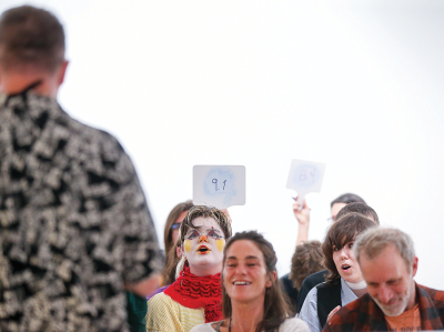  Audience member judges hold up scores following a poetry reading at the Oct. 30 Anton Art Center poetry slam. Harry Campion tallies up the scores  for each round.  