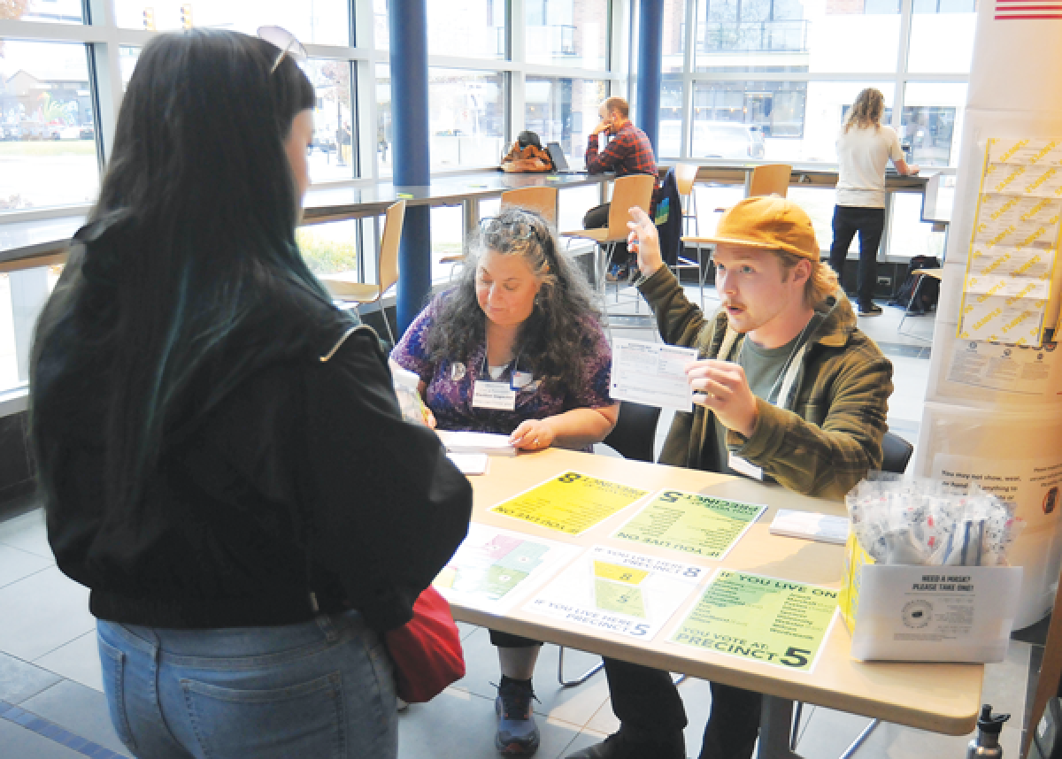  Michele Podzikowski and Cael Tanner assist a voter Nov. 5 at the Ferndale Area District Library.  