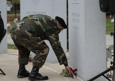  U.S. Army veteran John Adams places a bouquet of flowers at the base of one of the tablets at the American Veterans Memorial. The ceremony was part of a Veterans Day event at Resurrection Cemetery on Nov. 11. Adams is part of Vietnam Veterans of America Chapter 154’s color guard. 