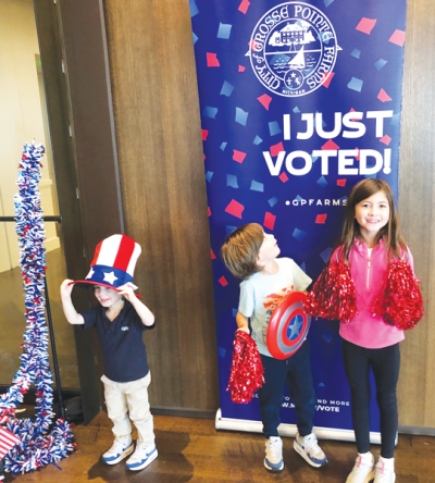  At a selfie station for Grosse Pointe Farms voters at The War Memorial, future Farms voters Vito Buccellato, 3, Rocco Buccellato, 5, and Gigi Buccellato, 7, don patriotic accessories.  