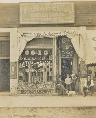  George Axford’s store on Rochester’s Main Street. Axford is seated on the left.  