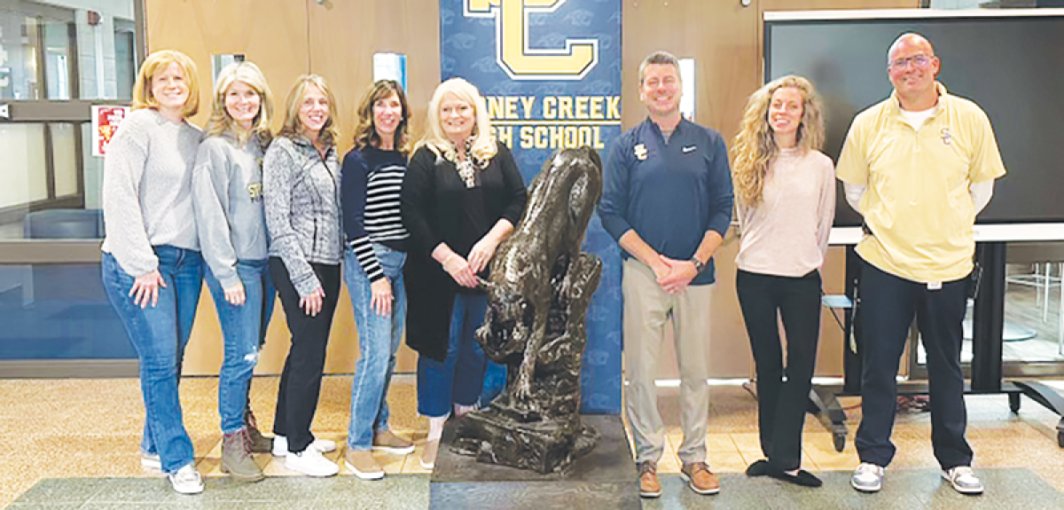  Rochester Hills Stoney Creek athletic booster members stand with the school’s brand-new statue. 