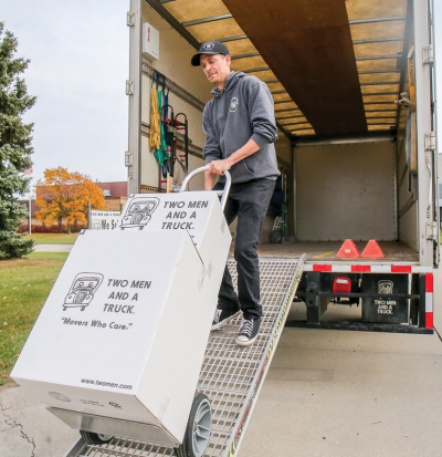  Mark Van Houw, general manager of Two Men and a Truck in Fraser, uses a ramp to load boxes on a truck. 