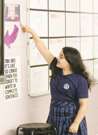  Regina High School sophomore Noor Shaaya reads a meme that Michelle DeGrez has in her classroom. Shaaya likes being part of the academic support program because it gives her a  chance to focus on her studies.  