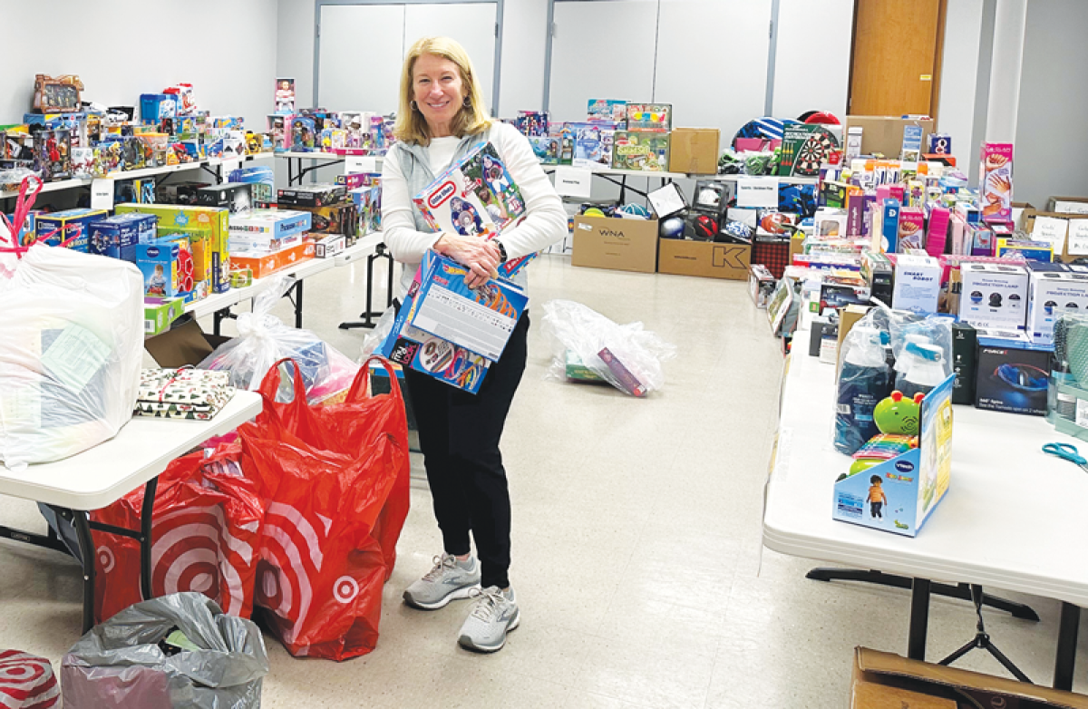  Neighborhood House Volunteer Barb Cenko sets up donated toys from the Giving Tree  program for clients to “shop” and pick out two toys for each child.  