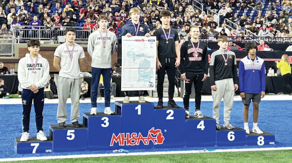  Grosse Pointe South senior Wyatt Hepner stands on the podium after winning the state championship in the 138-pound bracket. 