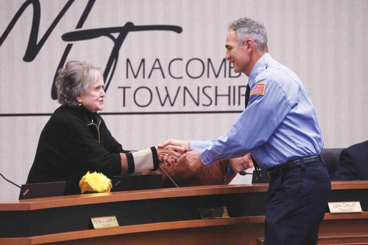  Macomb Township Trustee Nancy Nevers shakes hands with newly-hired part-time firefighter Anthony Cicchelli at the Nov. 13 Macomb Township Board of Trustees meeting. 