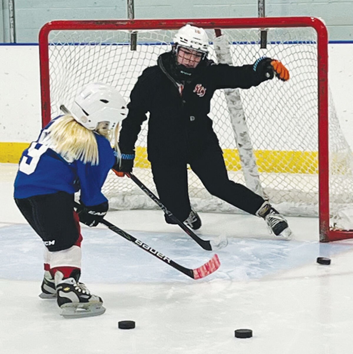  A coach attempts to block a young skater’s shot during a Skate Like a Girl session Nov. 16 at St. Clair Shores Civic Ice Arena. 