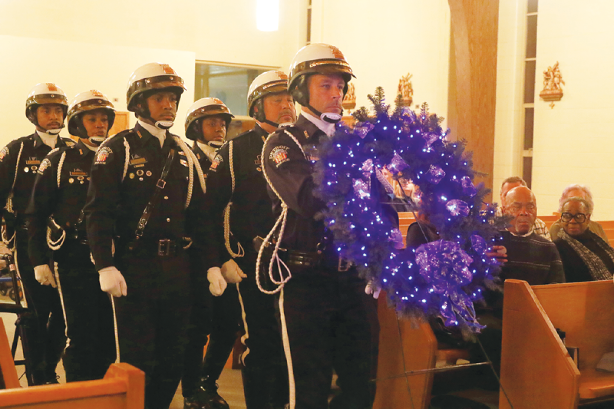  The Detroit Police Department Honor Guard presents a wreath in honor of fallen first responders during the  Project Blue Light ceremony at St. Justin Church in Hazel Park Dec. 3.  