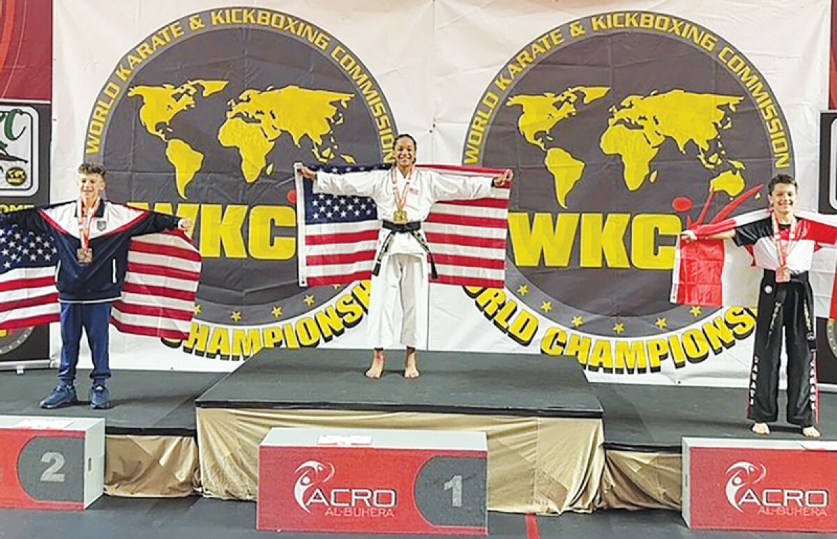  Malachi Randalle stands at the podium to celebrate one of his two gold medals he won at the 2024 World Karate & Kickboxing Commission World Championships in Portugal. 