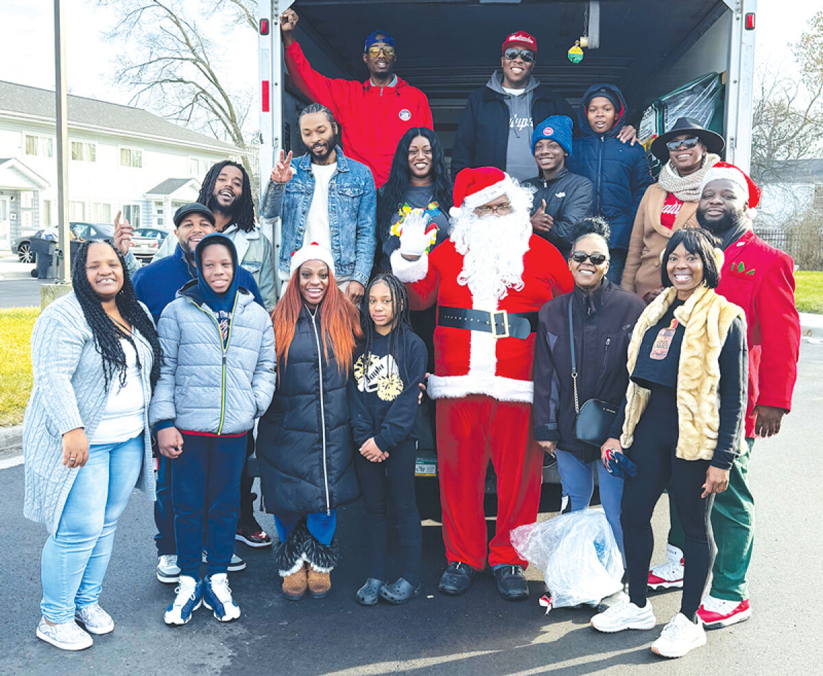  The Electrifyin’ Filthy Rockwell and a group of volunteers visit houses in Detroit the morning of Dec. 25 to deliver gifts to children and families during a past year’s Adopt-A-Block campaign. 